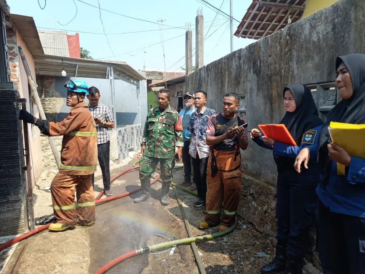 Petugas pemadam kebakaran melakukan pemadaman di rumah warga yang terbakar di Kelurahan Argasunya, Kecamatan Harjamukti, Kota Cirebon. 